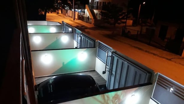 A multi-level parking structure with illuminated signs and a staircase. - Bangalôs do Parque (Penha)