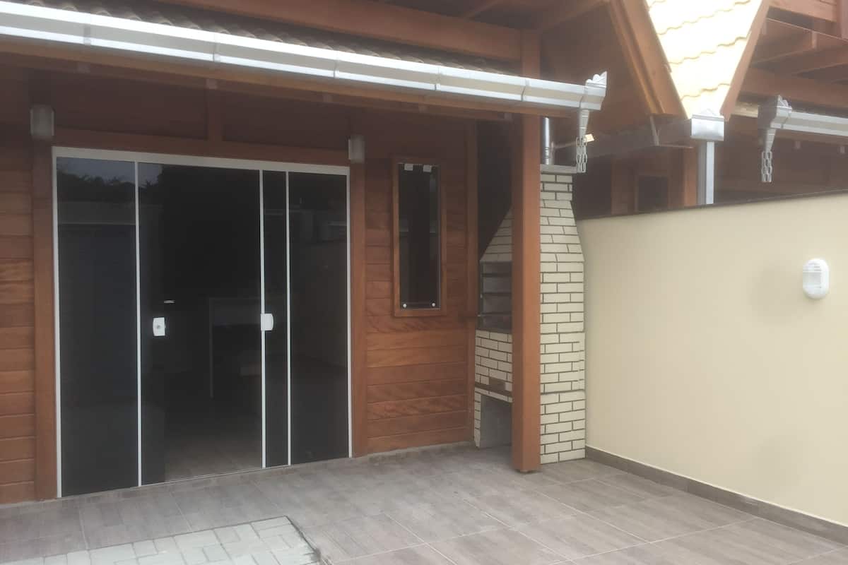 Un bâtiment à l’extérieur en bois, avec une porte en verre et un mur en briques.