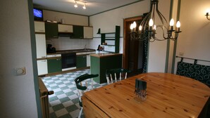 Une cuisine de taille réduite avec une table à manger, un lustre et un sol à carreaux.