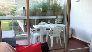 Ein modernes Zimmer mit einer Glastür, die zu einem Essbereich im Freien führt.