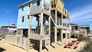 A multi-story wooden building with a balcony and a staircase.