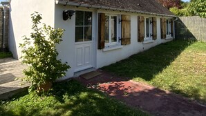 A single-story house with a sloped roof, white exterior walls, and a small front porch. - Maisonnette de Senlis rated 3*. Calm and excellent comfort (Senlis)