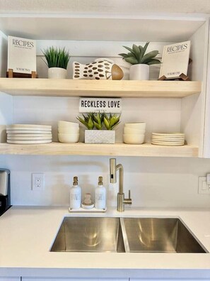 A kitchen with white shelves, a sink, and decorative items. - New Key Largo Escape• 2 Kings • Marina• Pickleball (Key Largo)