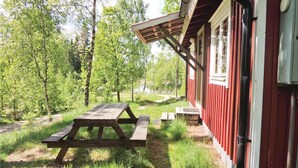 A red building with a picnic table and a covered area.