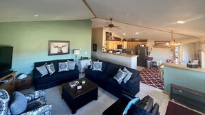 A living room with a dark-colored sofa set, a coffee table, and a television. - 1 Mile to ski Area / Amazing Views / Hot Tub - Five Star Reviews (Granby)