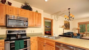 Una cocina con armarios de madera, electrodomésticos de acero inoxidable y una isla grande con un lavamanos.