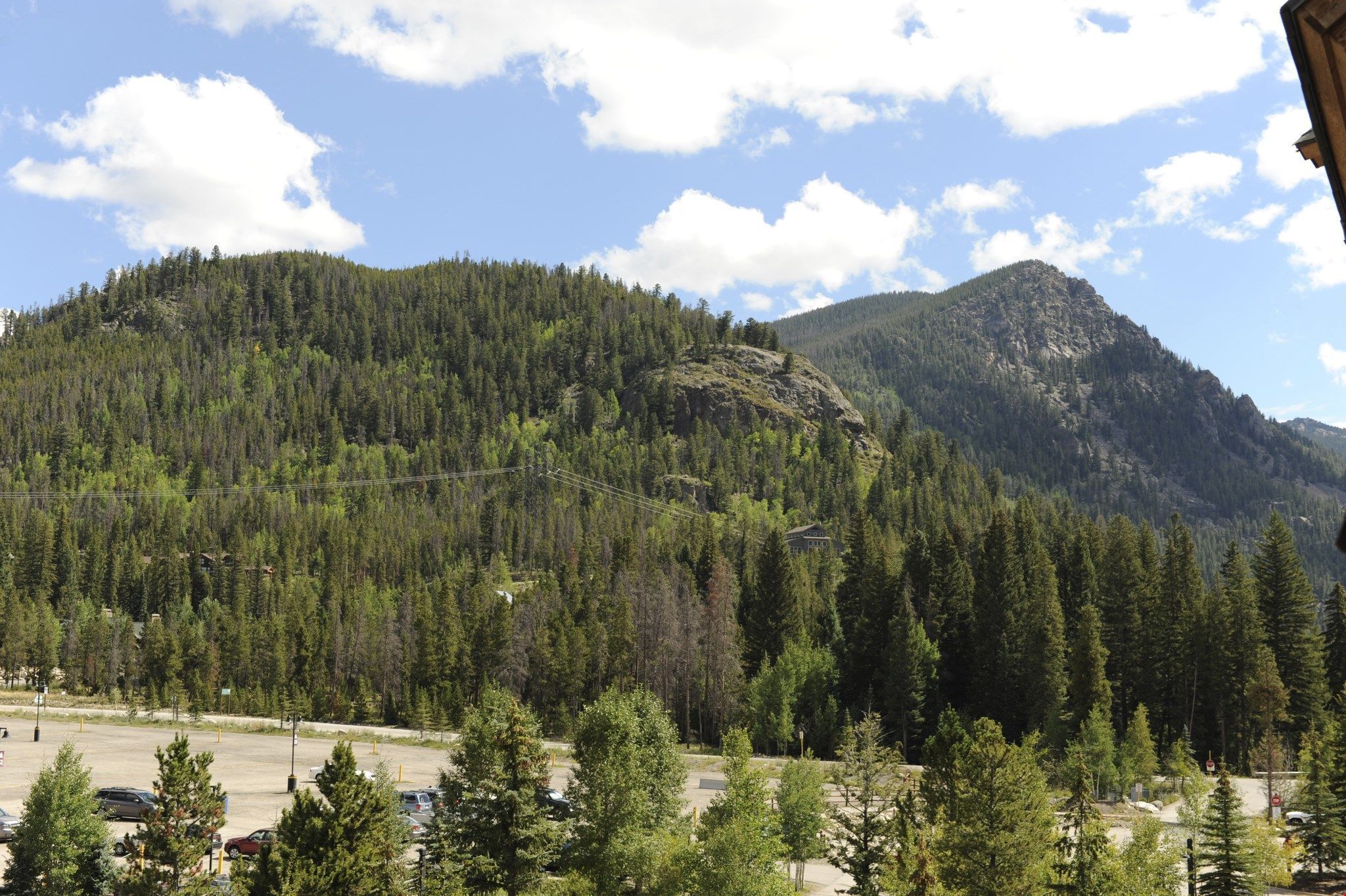 A mountainous landscape with dense forests and a clear sky.