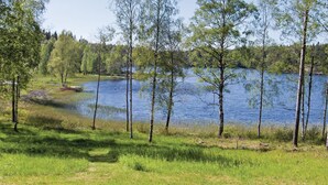 Eine natürliche Landschaft mit einem See, Bäumen und einem kleinen Steg.
