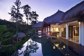 A modern resort with thatched-roof villas, a reflective pool, and lush tropical vegetation. - Elegant, Intimate, Luxury Contemporary Balinese Villa  In a Traditional Village  (Kemenuh, Sukawati,)