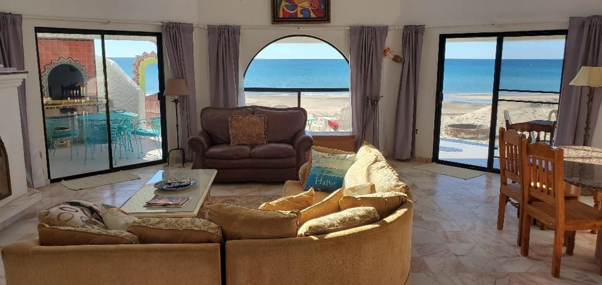 Large sectional couch, ocean/patio view. Light bright and open living room.