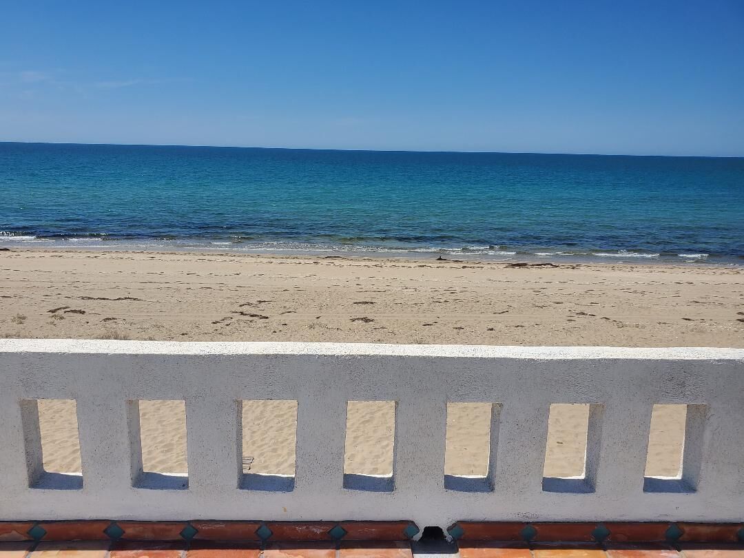 Een strand met helder uitzicht op de oceaan en een zandstrand.