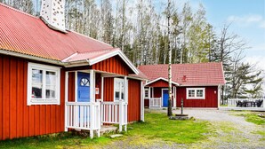 A row of red wooden cabins with white trim, each featuring a porch and a blue door. - 2 bedroom lovely home in Hyltebruk (Hyltebruk)