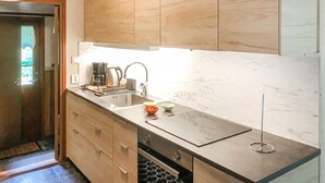 Eine moderne Küche mit Holzschränken, einer Edelstahl-Spüle und einer Marmor-Spritzschutzwand.