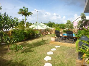 Relax in a serene outdoor space surrounded by lush greenery and a small pool.