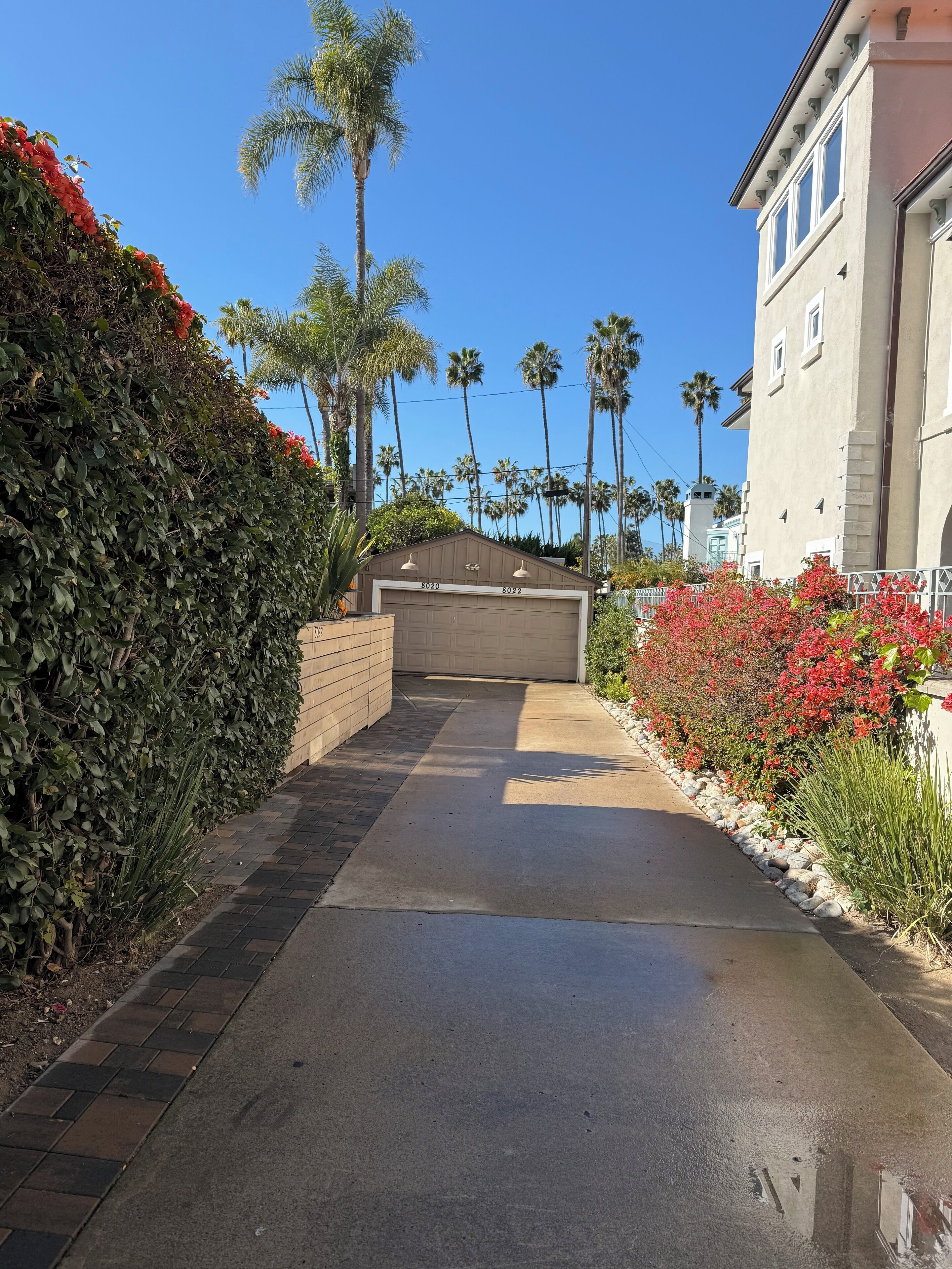 A residential driveway leading to a garage with a number 8020 garage door.
