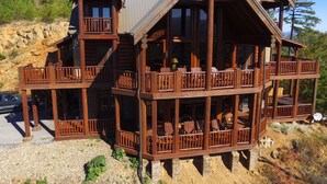 A multi-story log cabin with balconies and a stone foundation. - Majestic Mountaintop Retreat- Breathtaking Views, Luxury Lodge over Pigeon Forge (Sevierville)