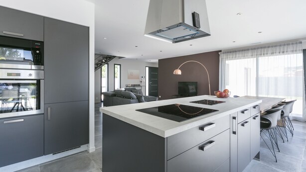 A modern kitchen with a central island, built-in appliances, and a dining area with a large window. - Superb new contemporary villa with private pool 400 m from the sea  (Agde)