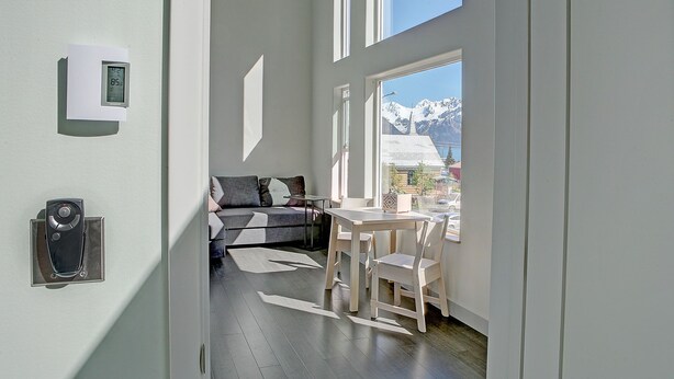 A modern interior with a sofa, a dining table, and chairs. - Modern Accommodations with Luxurious View (Seward)