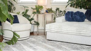 A cozy living room with a high ceiling, two windows, a ceiling fan, and a variety of plants. - Botanical Loft in Amish Country, King Bed, Jetted Tub & Garden Patio (Bird-In-Hand)