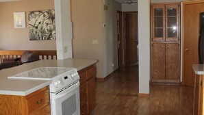 A kitchen with wooden cabinets, a white stove, and a patterned rug.