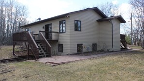 A single-story building with a covered porch and a small staircase leading to a deck.