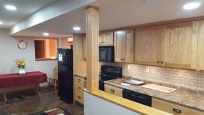 A kitchen with wooden cabinets, a refrigerator, a microwave, a stove, and a dishwasher.