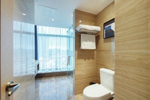 A modern bathroom with a toilet, a towel rack, and a glass shower enclosure. - Novotel Wuxi (Wuxi)