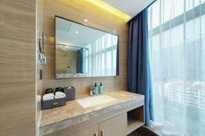 A modern bathroom with a large mirror, a sink, and a shower. - Novotel Wuxi (Wuxi)