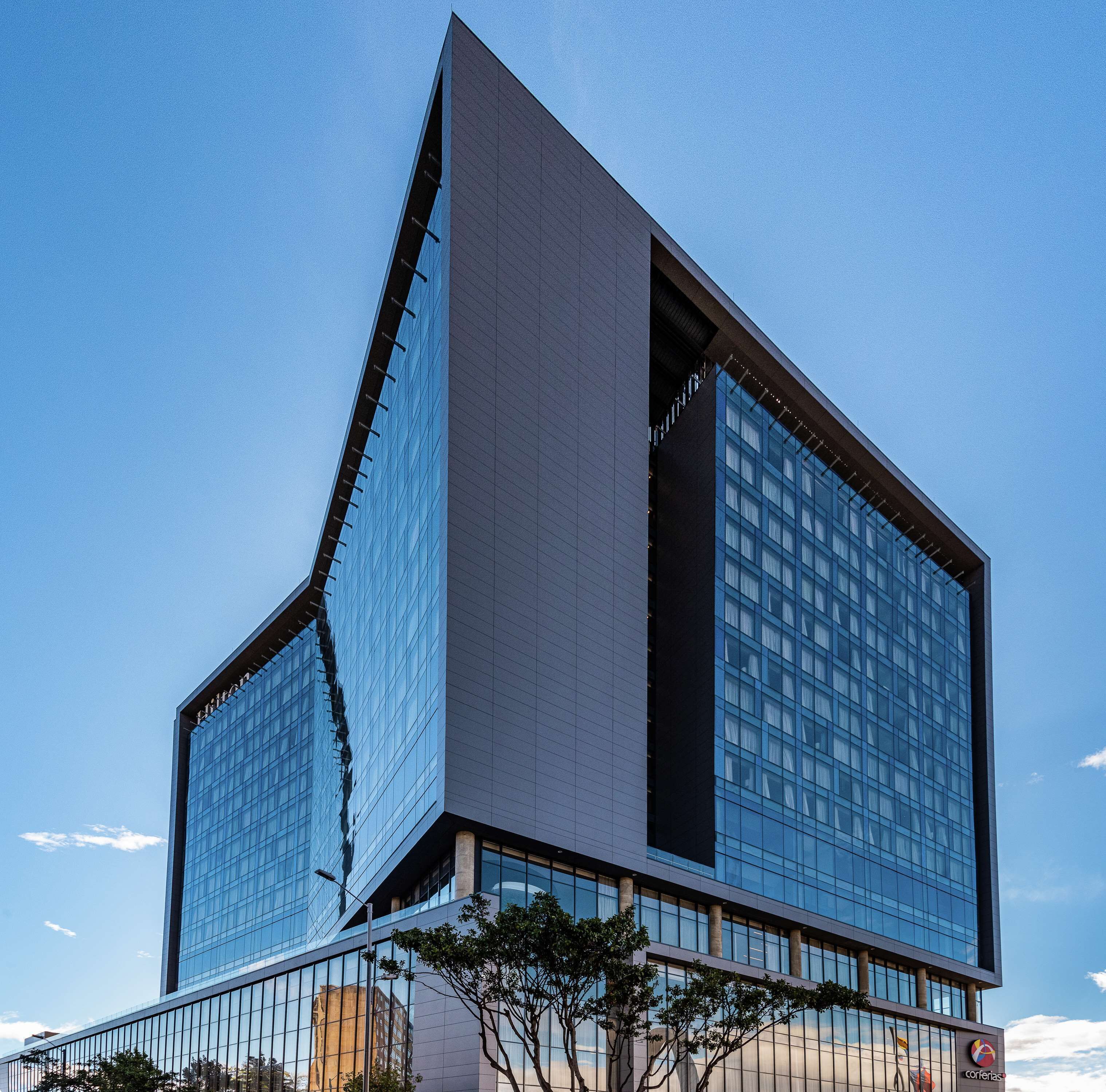 Un edificio moderno con llamativo diseño triangular, grandes ventanales y techo plano.