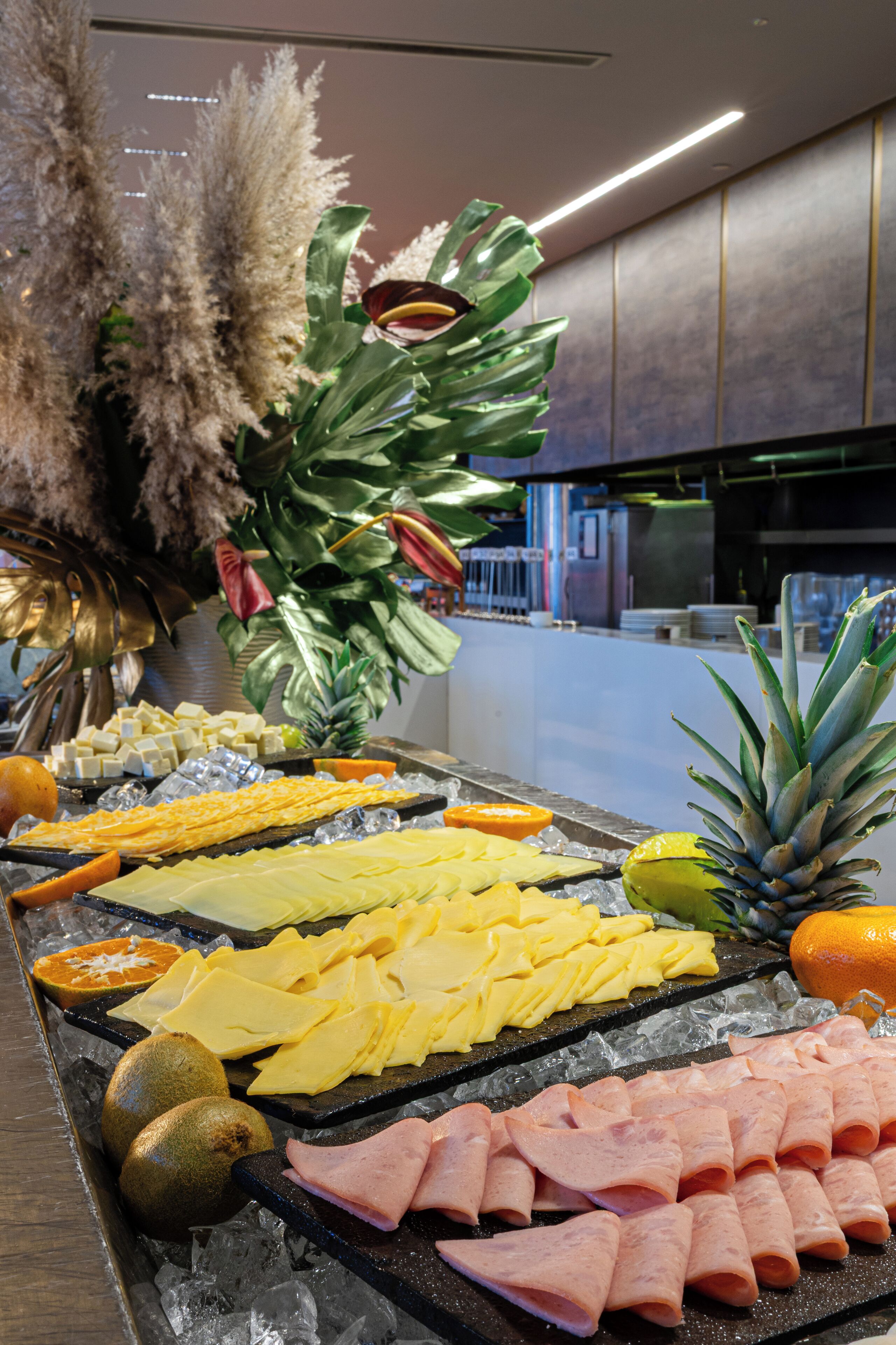 Un bufé con diversas opciones de comida, como queso, frutas y embutidos.