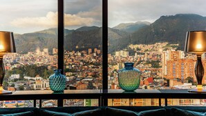 A cityscape view from a window with two vases on a table.