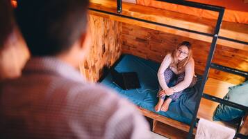 A bunk bed with a laptop on the lower bunk.