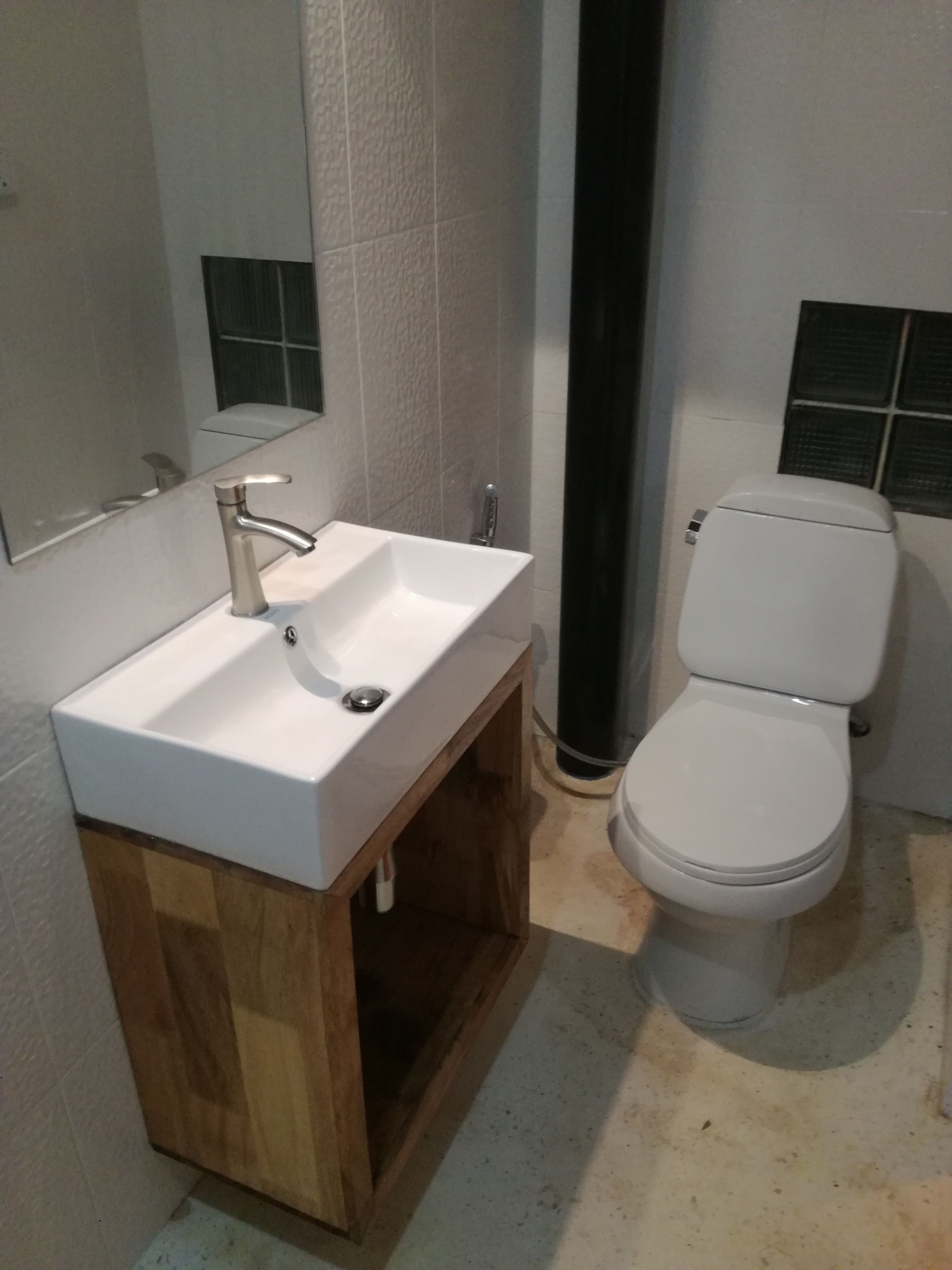 Un baño con un lavamanos blanco, un espejo y un inodoro blanco.