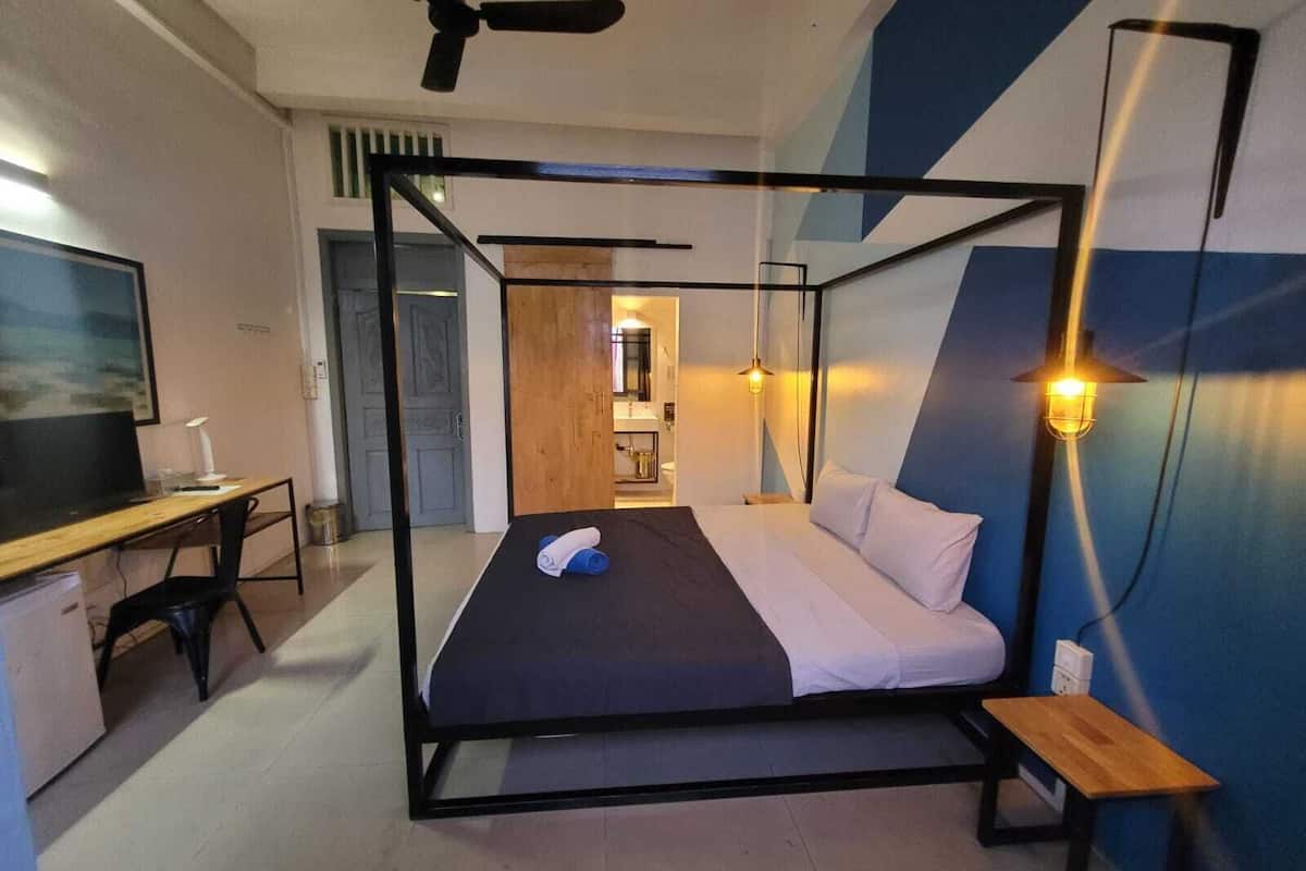 A modern room with a bed, desk, and chair.