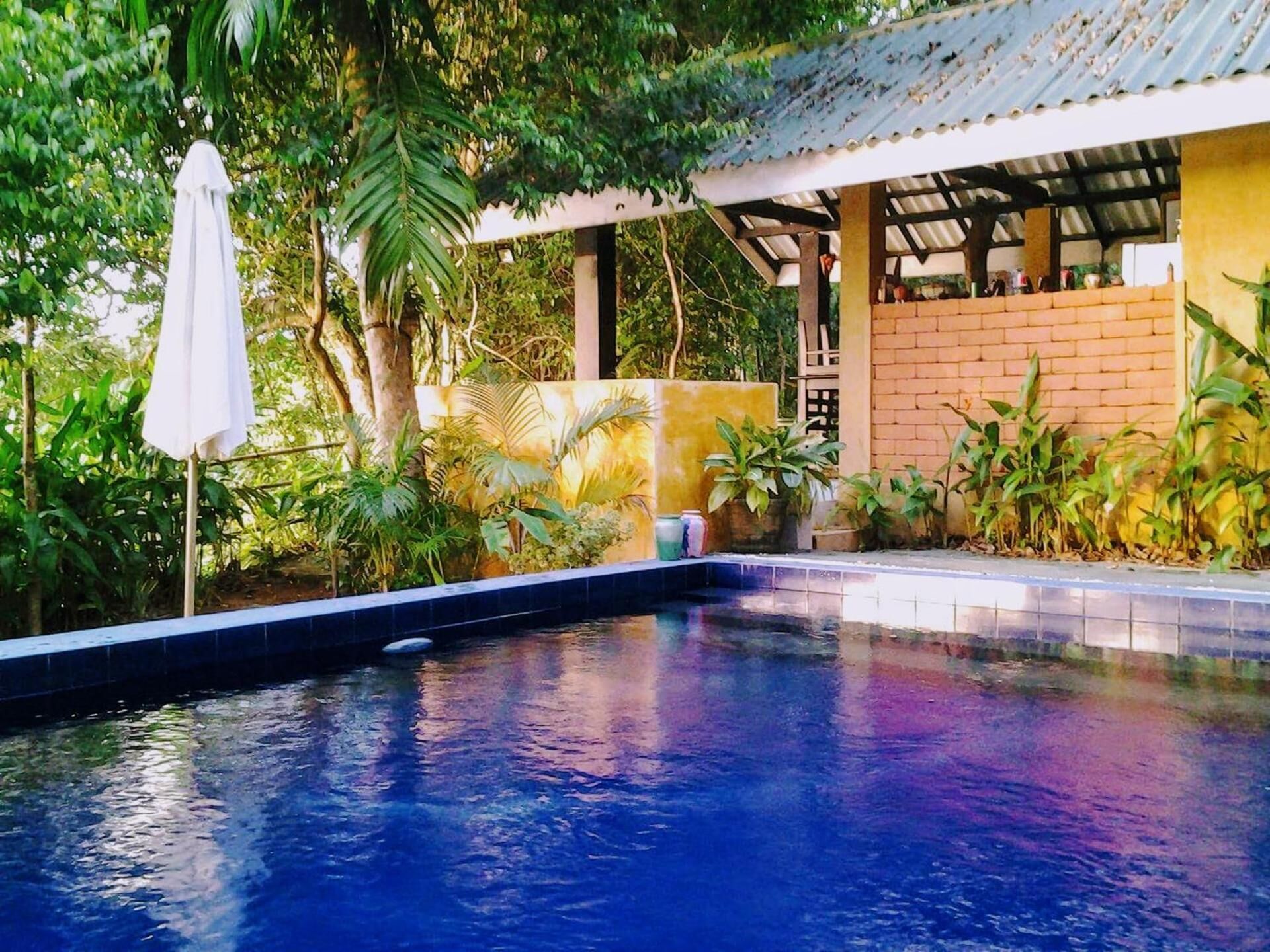 Una piscina al aire libre, sillones reclinables de piscina