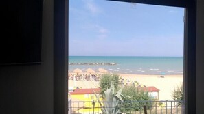 Vista di una spiaggia con ombrelloni e un edificio sullo sfondo.