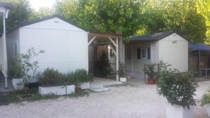A small, white, single-story building with a covered porch and a small attached shed. - Camping Borghetti (Ortona)