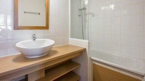 A bathroom with a white sink, wooden vanity, a glass shower enclosure, and a mirror with a wooden frame. - 43m² Apartment in Plagne 1800, pets allowed, parking included (La Plagne 1800)