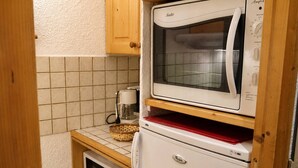 A compact kitchen with a microwave, a coffee maker, and a refrigerator. - Charming studio in Laitelet, ski-in/ski-out, near shops (Les Allues-Méribel)