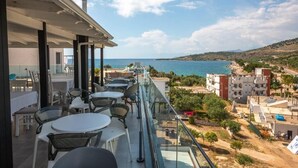 Un balcon avec coin salon extérieur donnant sur une vue panoramique de la côte.