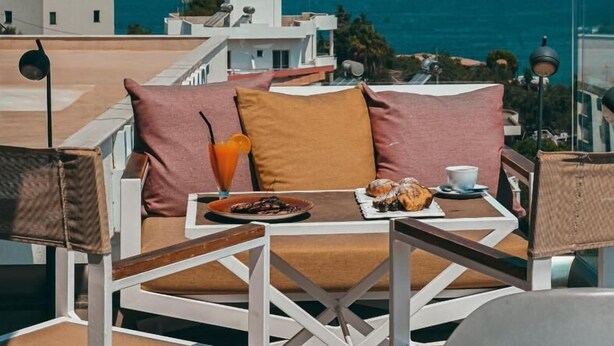 A balcony with a table set for breakfast, overlooking a coastal view. - Bianco Hotel (Ksamil)