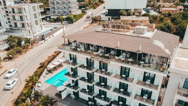 Un hôtel à plusieurs étages doté d’une piscine sur le toit, de balcons et d ’une architecture moderne.