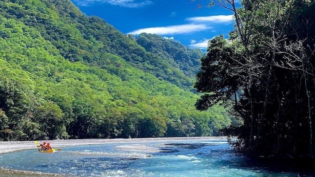 Un río de aguas cristalinas rodeado de colinas verdes y exuberantes.