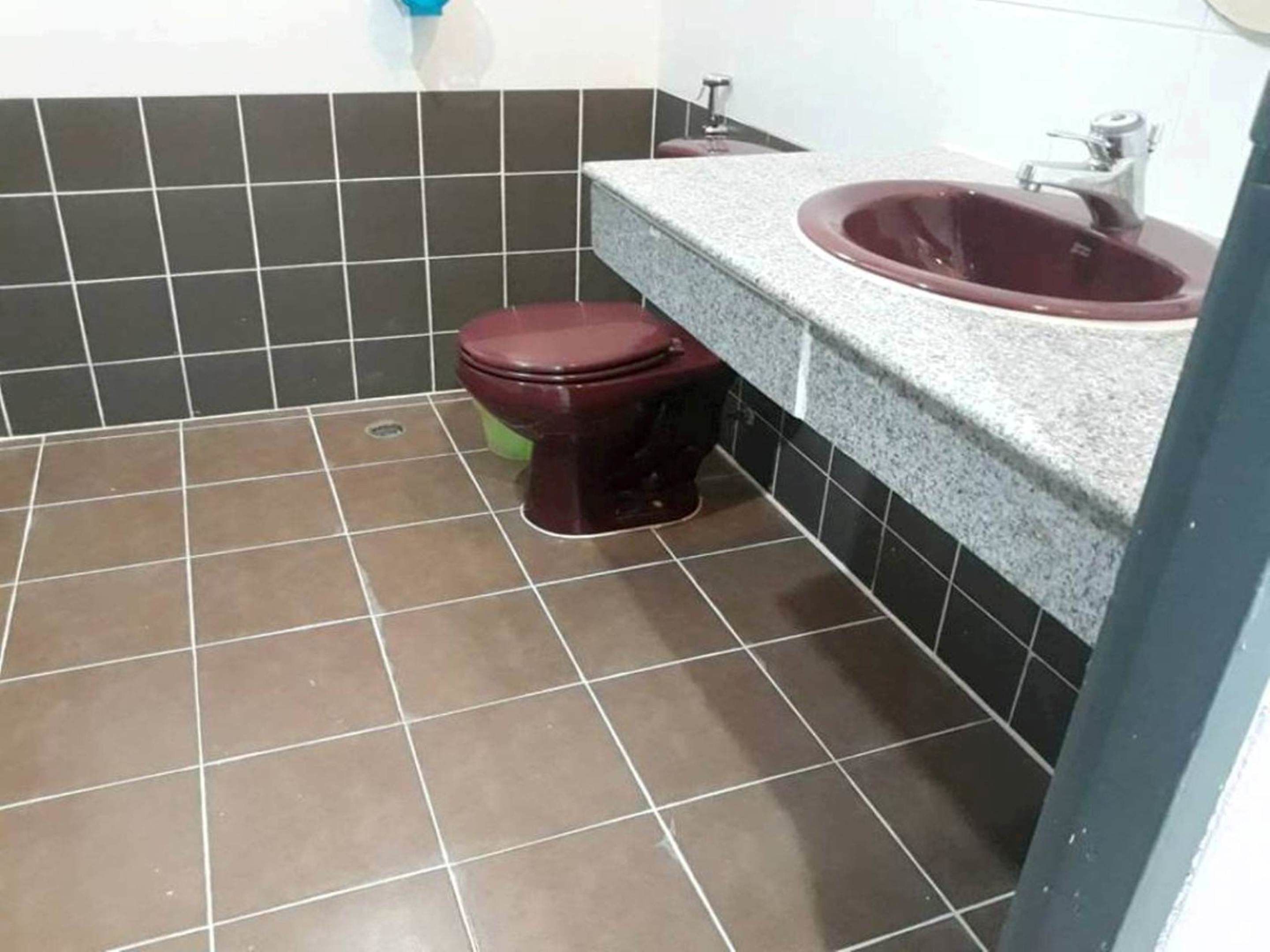 A bathroom with a toilet, sink, and tiled floor.