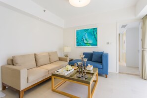 Suite Deluxe, vue sur la mer | Salle de séjour | Téléviseur ACL