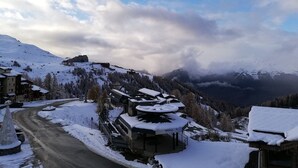 A snow-covered mountain village with a road leading to a building with a sign 'Telabus'. - Cozy studio in Plagne Villages near slopes, balcony, 4 ppl (La Plagne)