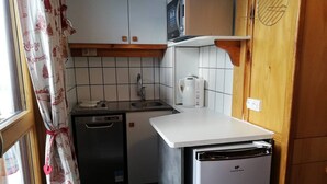 A compact kitchen with a dishwasher, a microwave, and a coffee maker. - Cozy studio in Plagne Villages near slopes, balcony, 4 ppl (La Plagne)
