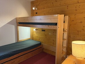 A bunk bed with a window and a lamp.