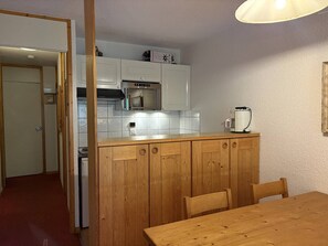 Una cocina con armarios de madera, un microondas y una cafetera en la encimera.