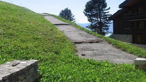 A stone staircase leading up a grassy hill with a wooden building at the top. - Cozy studio for 2, terrace, pets allowed (La Plagne)